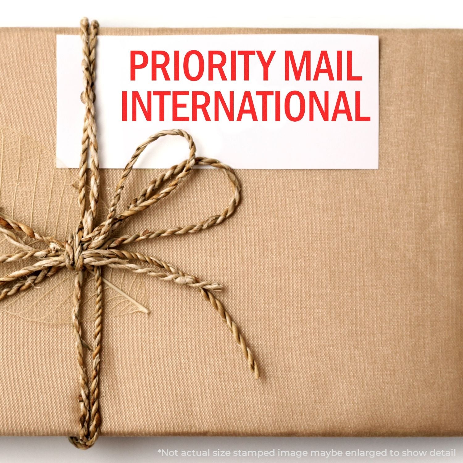 A brown package tied with twine, featuring a Self Inking Priority Mail International Stamp in red text on a white label.