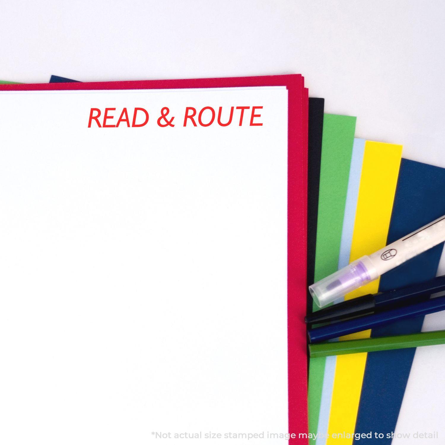 Large Self Inking Read & Route Stamp used on a stack of colorful papers with a pen and highlighter nearby.