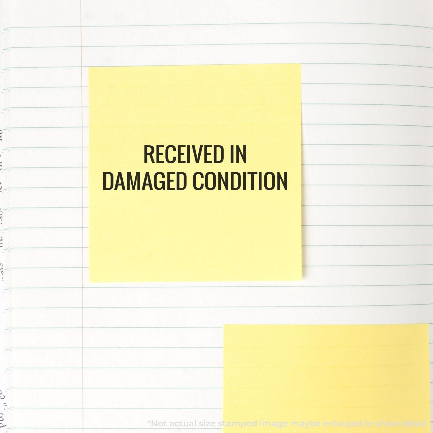 Large Pre-Inked Received in Damaged Condition Stamp used on a yellow sticky note placed on a lined notebook page.