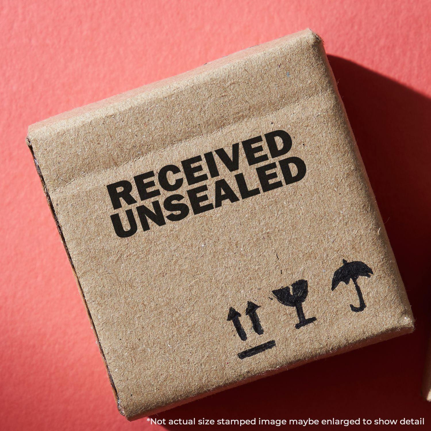 Cardboard box stamped with RECEIVED UNSEALED using the Large Self Inking Received Unsealed Stamp, displayed on a red background.