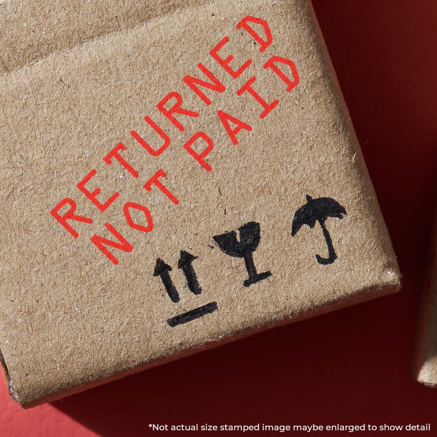 Close-up of a cardboard box stamped with RETURNED NOT PAID in red ink using the Self Inking Returned Not Paid Stamp.