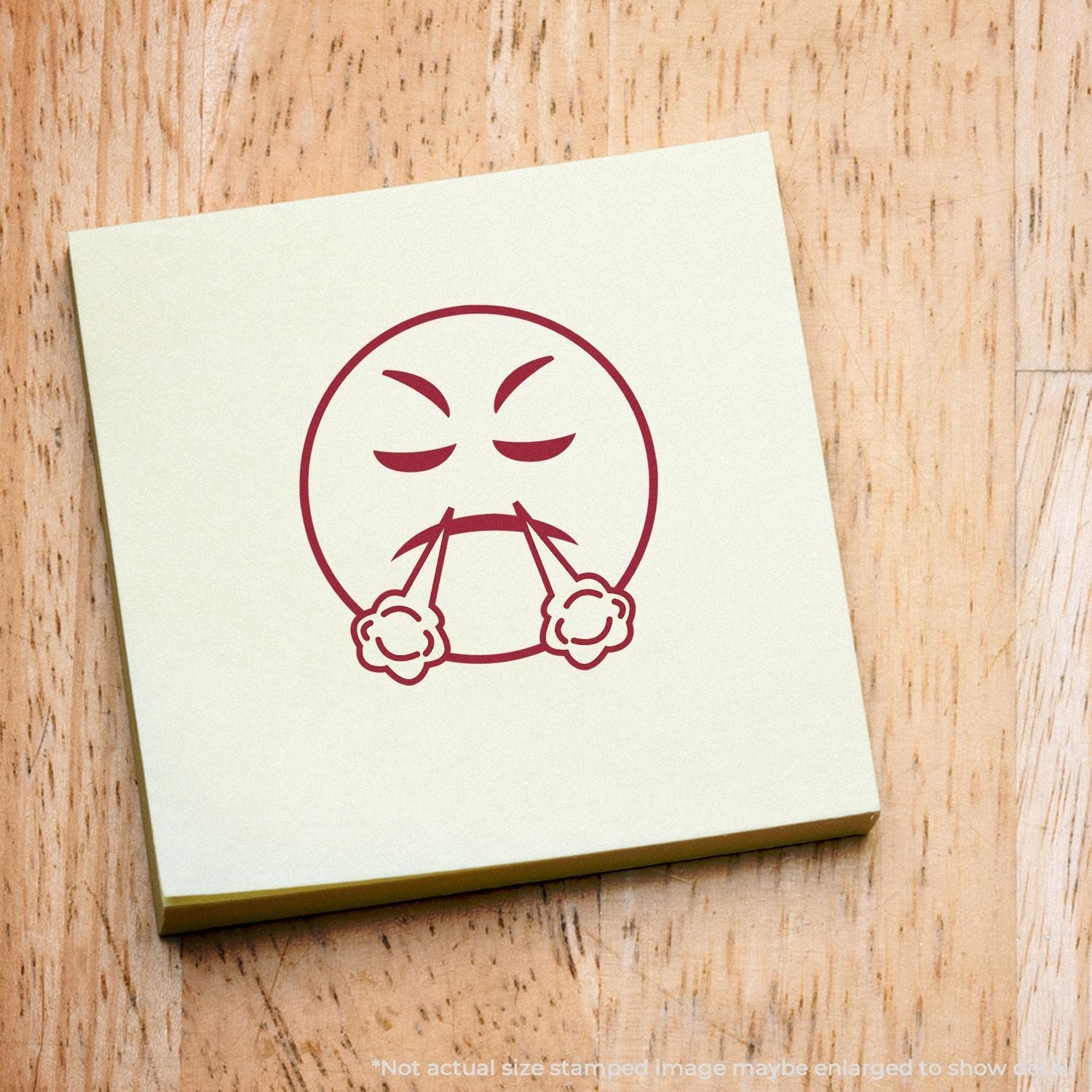 Self Inking Round Angry Smiley Stamp imprint on a yellow sticky note, showing an angry face with steam coming out of its nostrils.