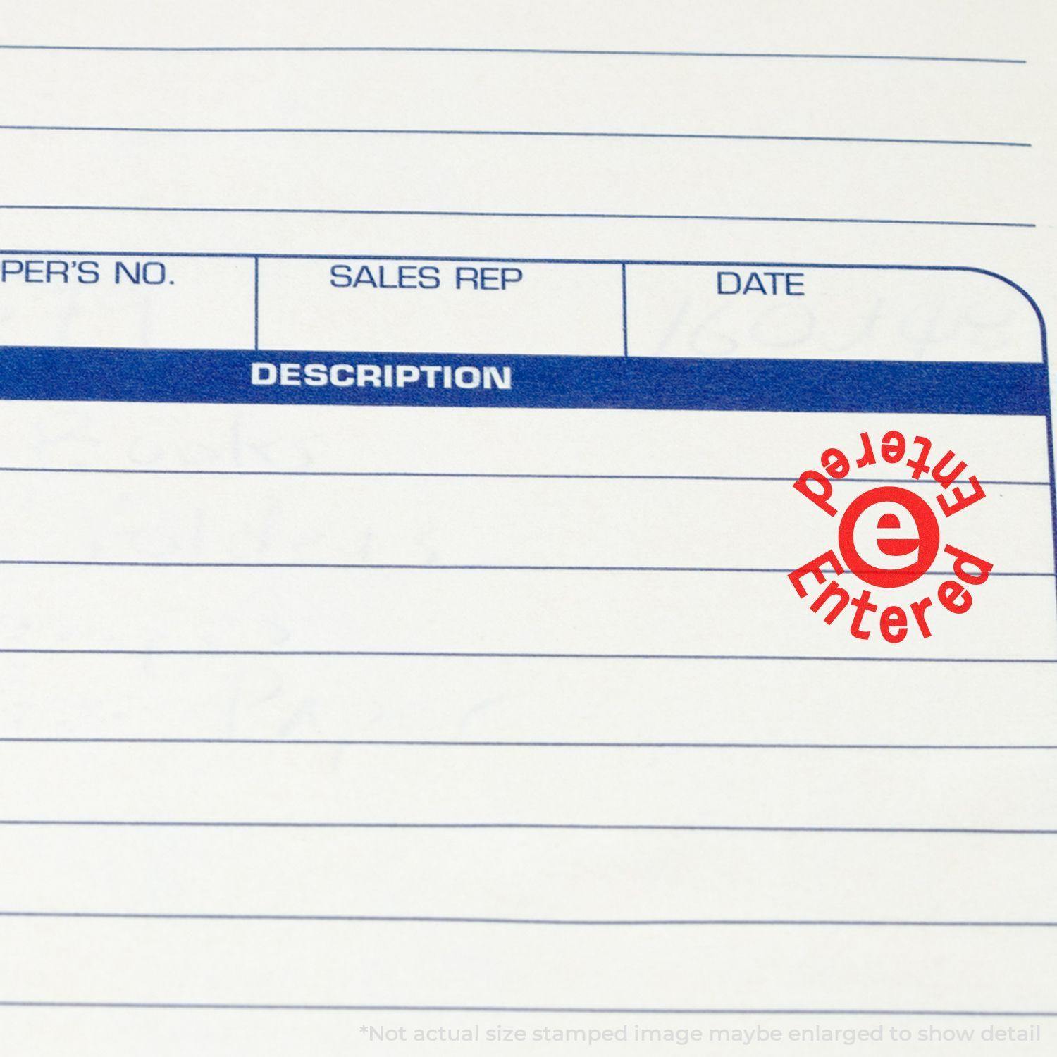 Close-up of a form with a red round 'Entered Entered' rubber stamp mark in the description section.