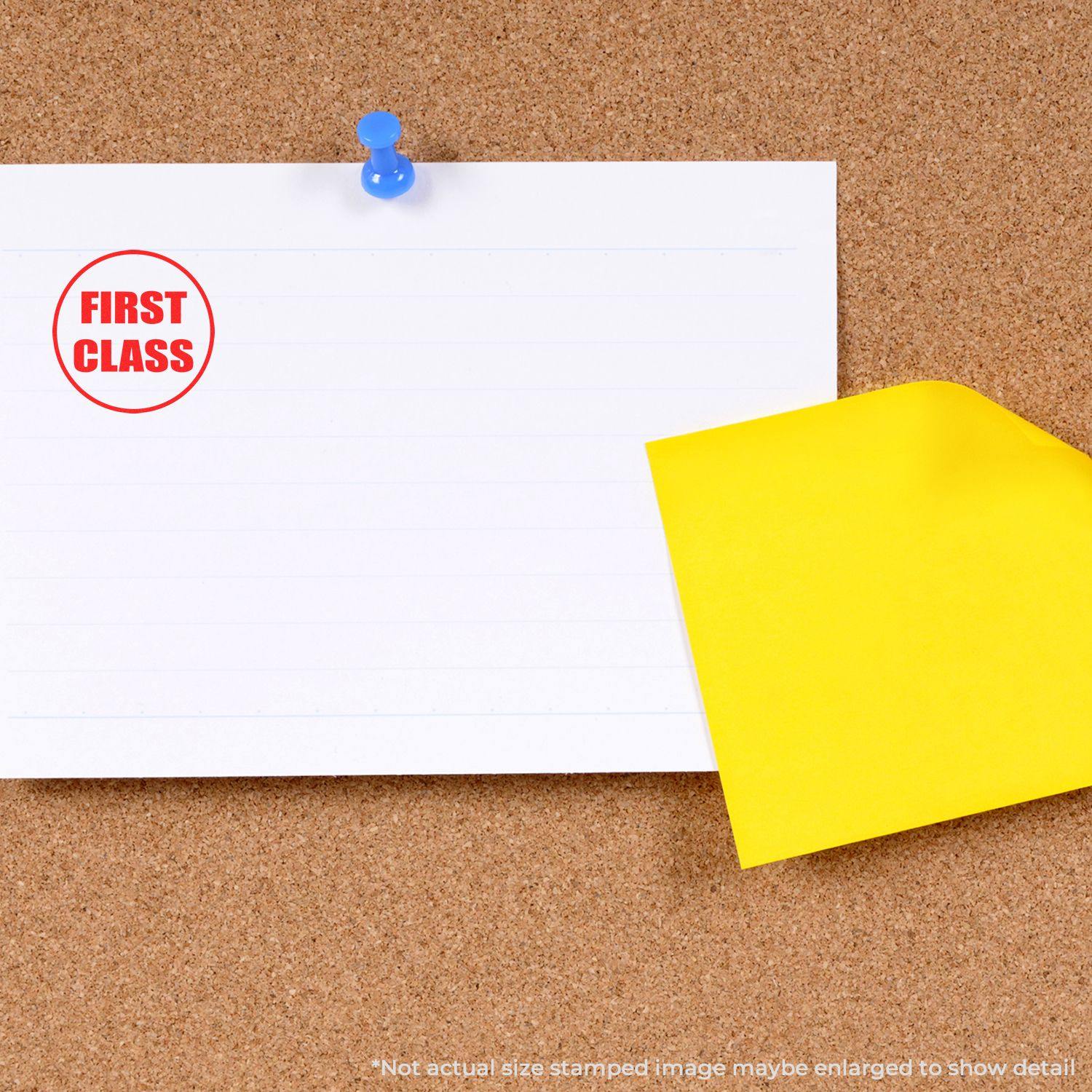 Round First Class rubber stamp on a white paper pinned to a corkboard, with a yellow sticky note partially covering the paper.