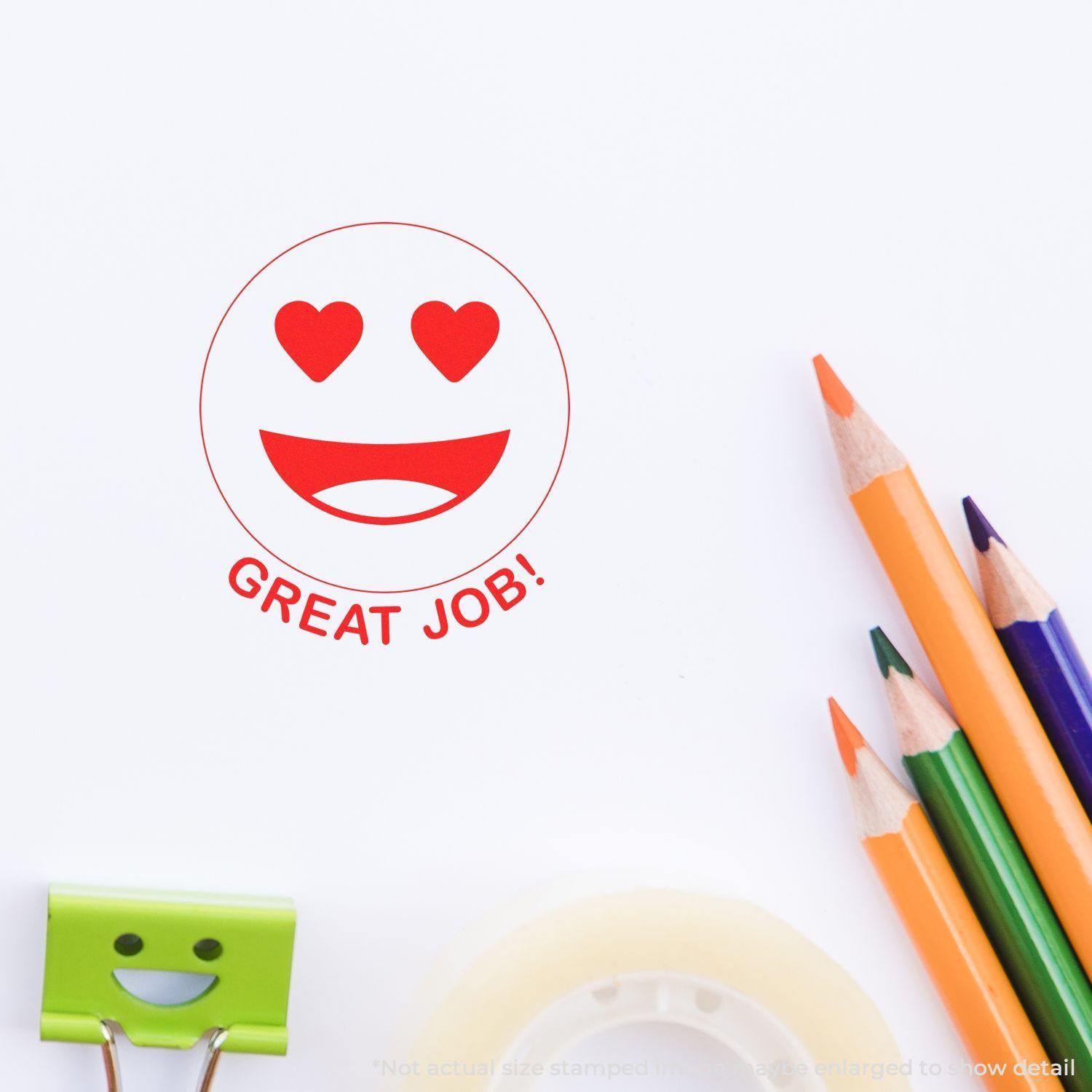 Round Great Job Smiley Rubber Stamp with heart eyes and a wide smile on paper, surrounded by colored pencils and office supplies.