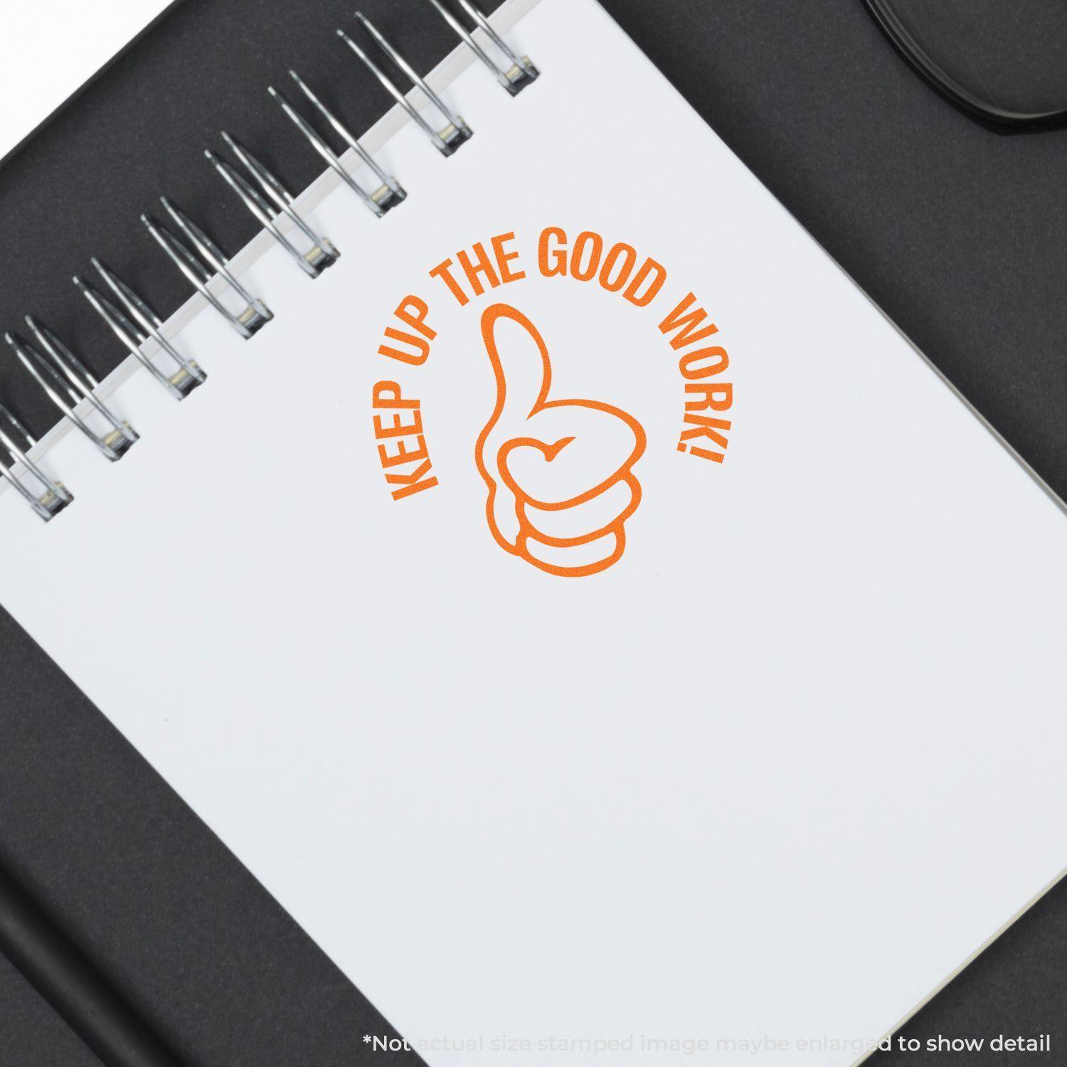 Round Keep up the Good Work rubber stamp in orange ink on a white notepad with a thumbs-up symbol.