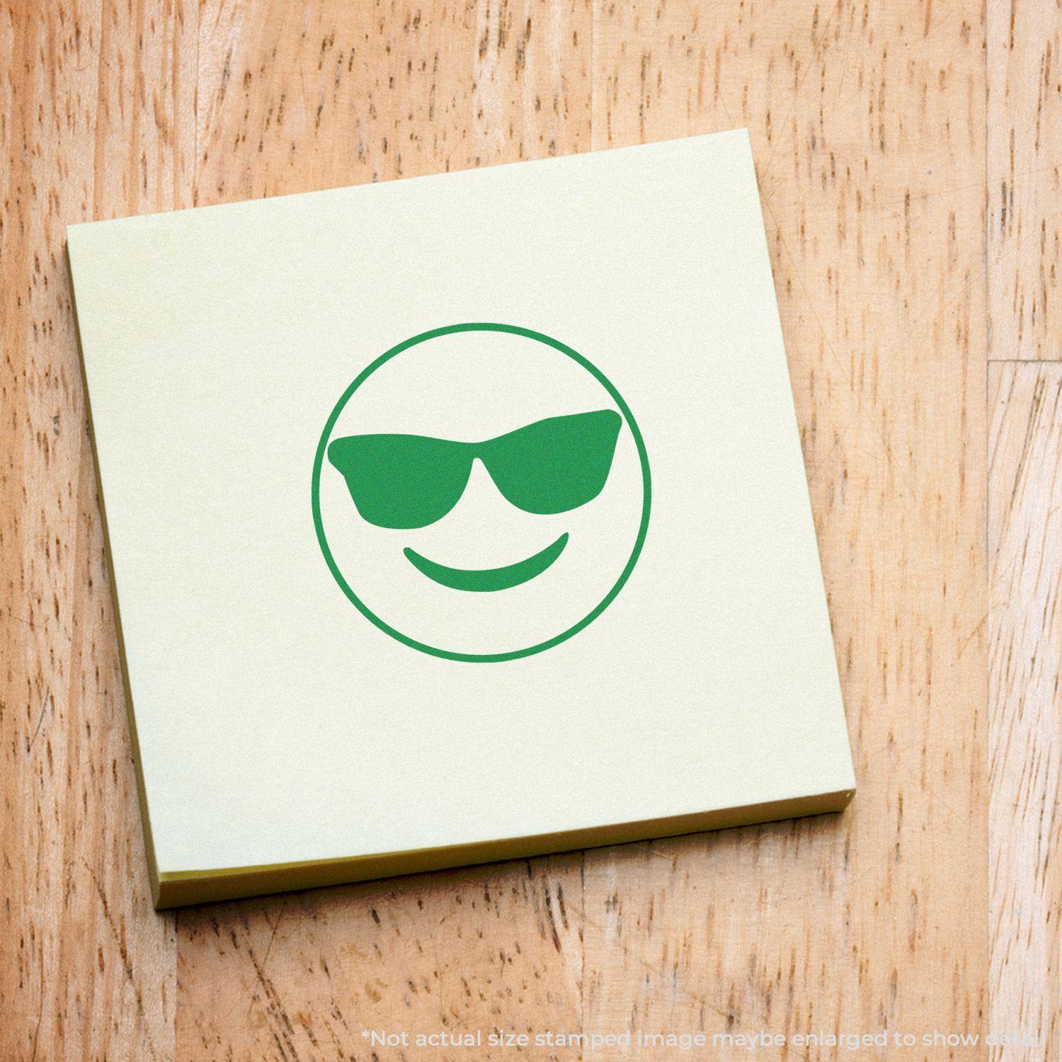 Round Smiley with Sunglasses Rubber Stamp on a wooden surface, featuring a green smiley face with sunglasses on a yellow sticky note.