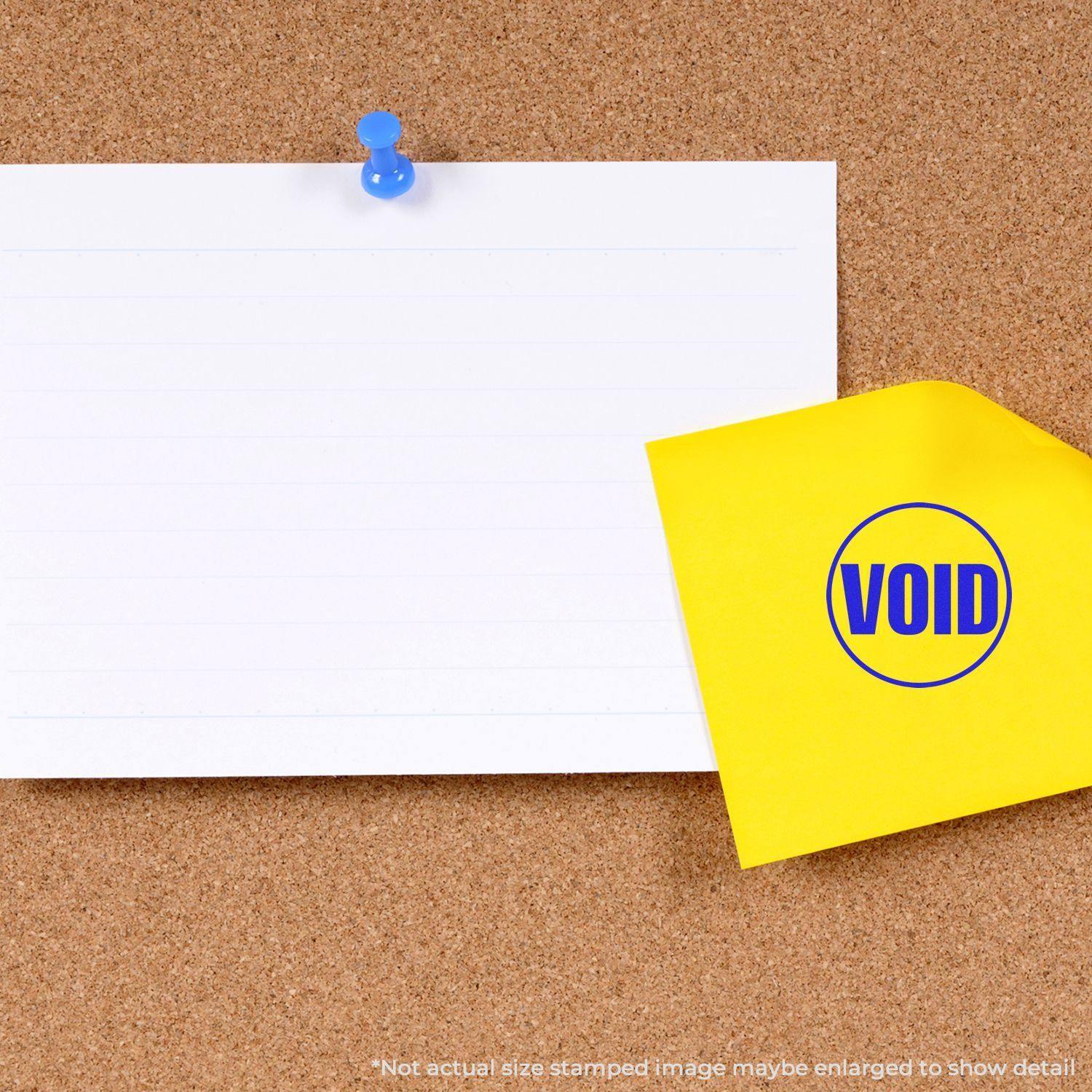 A round void rubber stamp on a yellow paper next to a blank white note pinned on a corkboard.