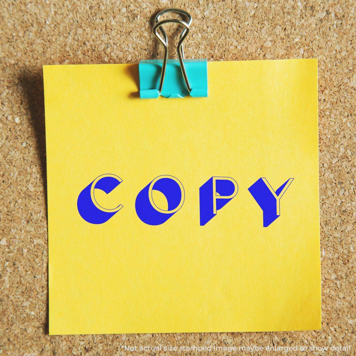 Yellow note with COPY stamped in blue using the Large Pre-Inked Shadow Copy Stamp, clipped to a corkboard with a blue binder clip.