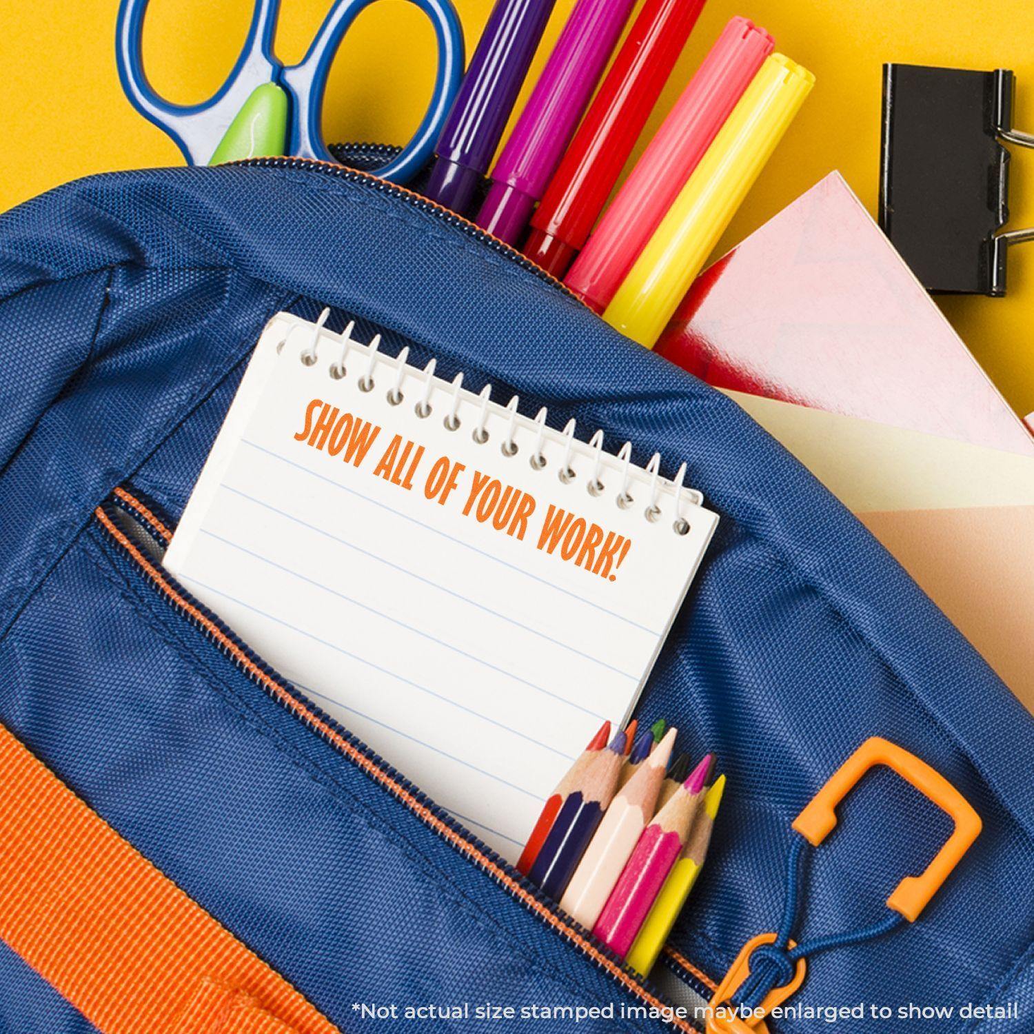 A blue backpack with school supplies and a notepad stamped with Show All Of Your Work in orange letters.