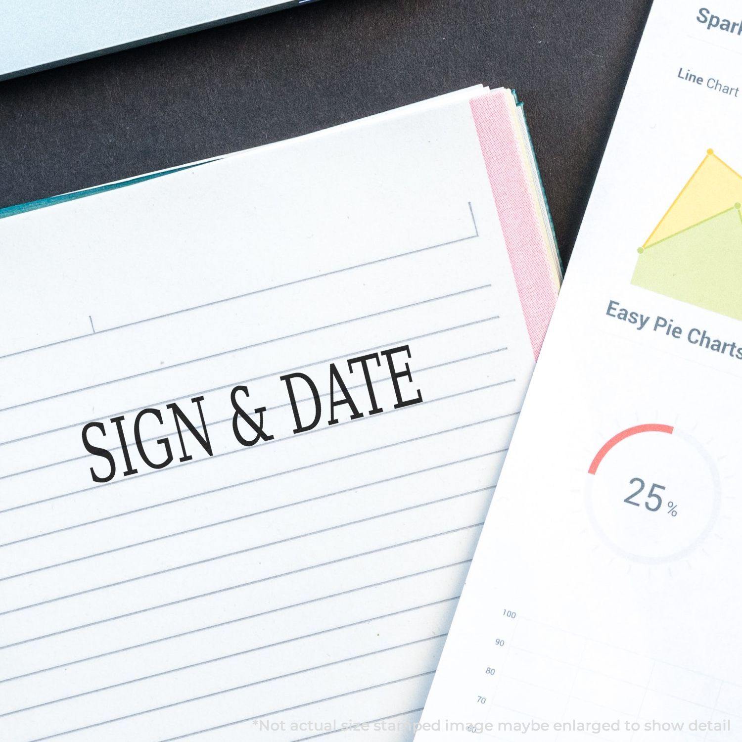 Slim Pre-Inked Sign & Date Stamp used on a lined paper beside a chart with a 25% pie graph and a laptop corner visible.