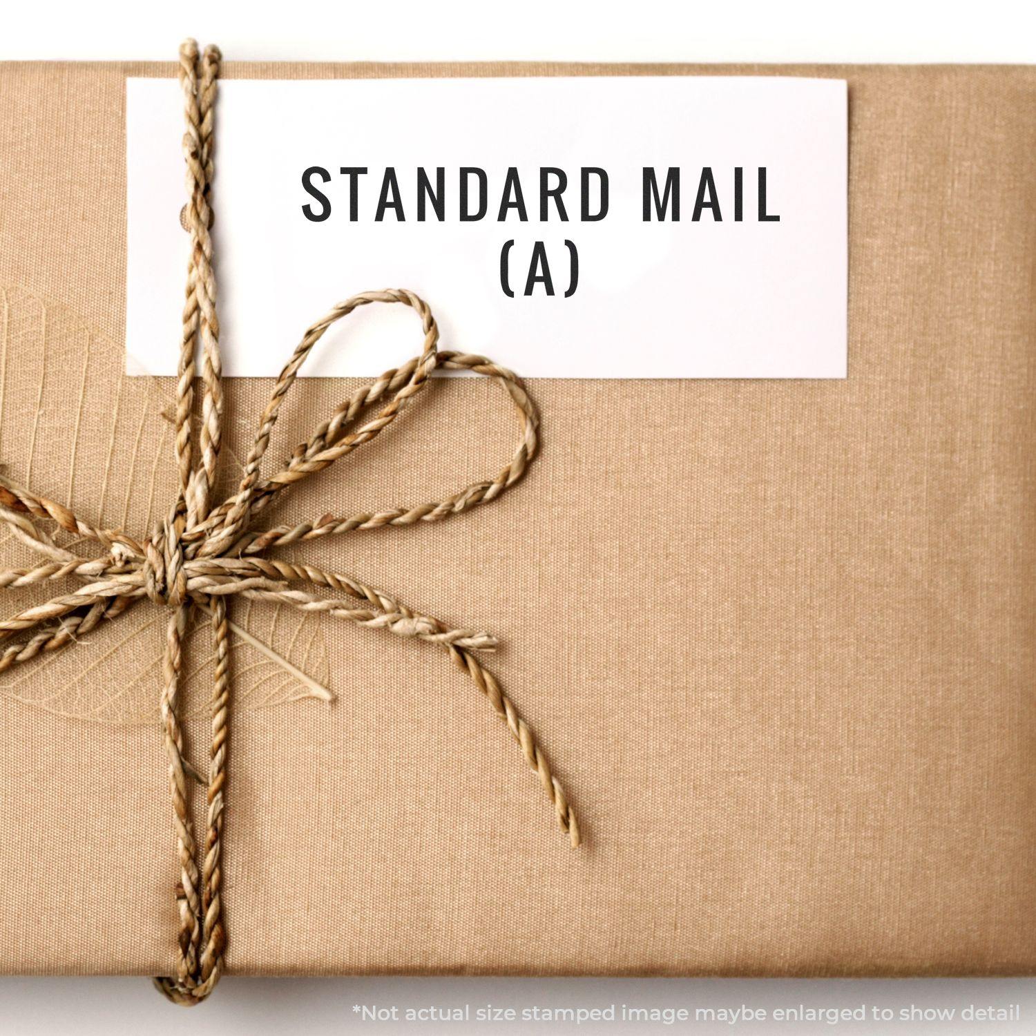 A brown package tied with twine and labeled STANDARD MAIL (A) using the Large Pre-Inked Standard Mail (A) Stamp.