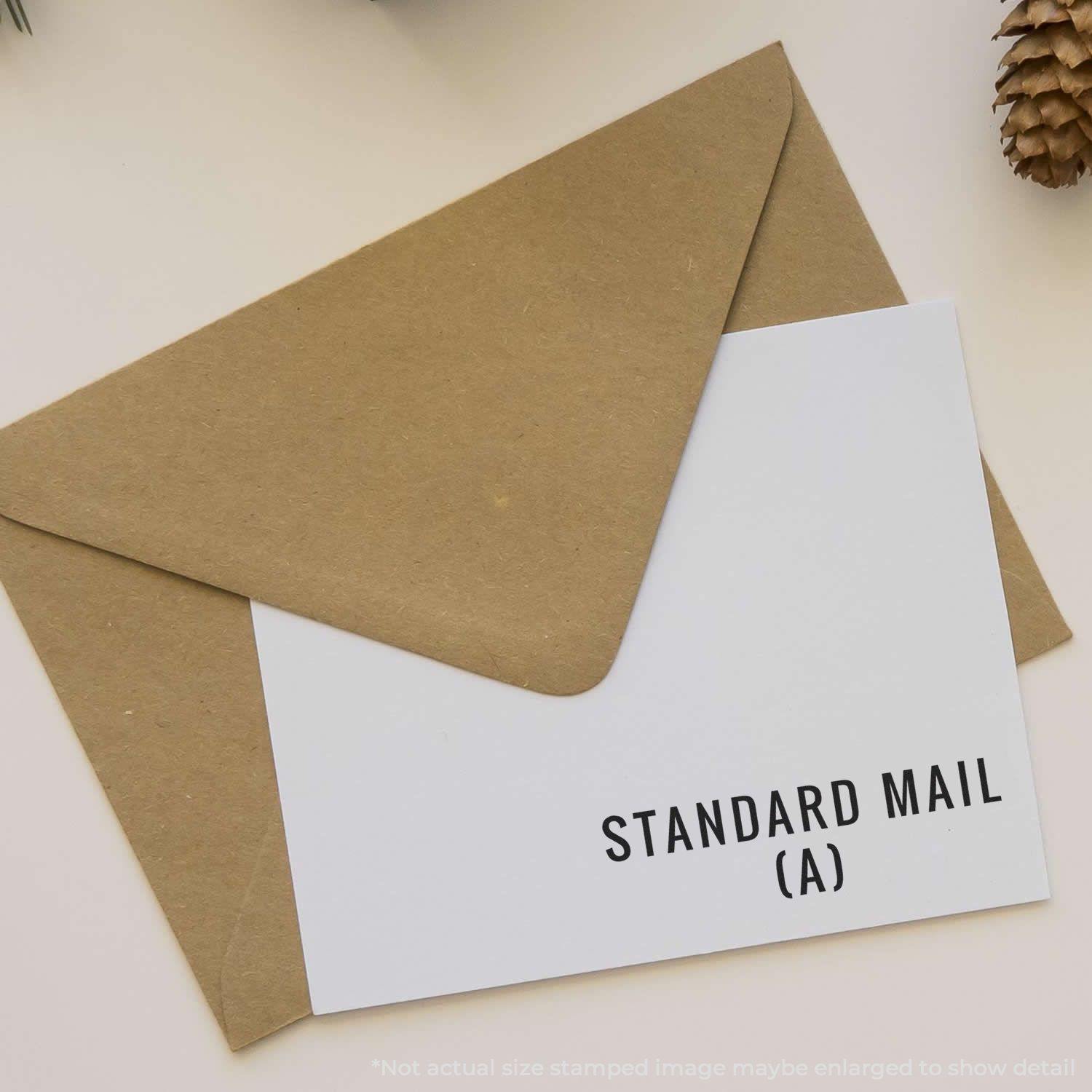 Envelope with a card stamped STANDARD MAIL (A) using the Self Inking Standard Mail (A) Stamp, placed on a beige surface.