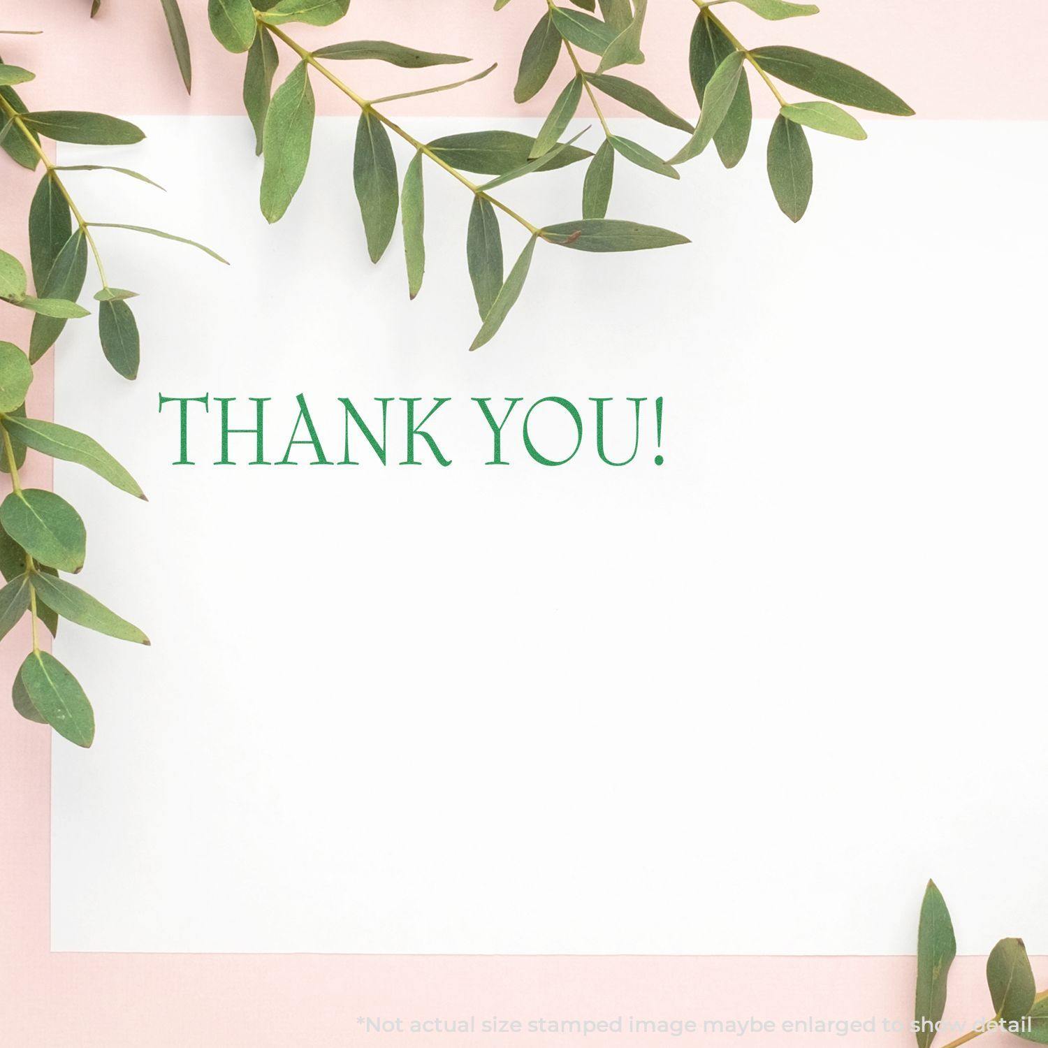 A white card with THANK YOU! stamped in green using the Large Pre-Inked Thank You Stamp, surrounded by green leaves on a pink background.