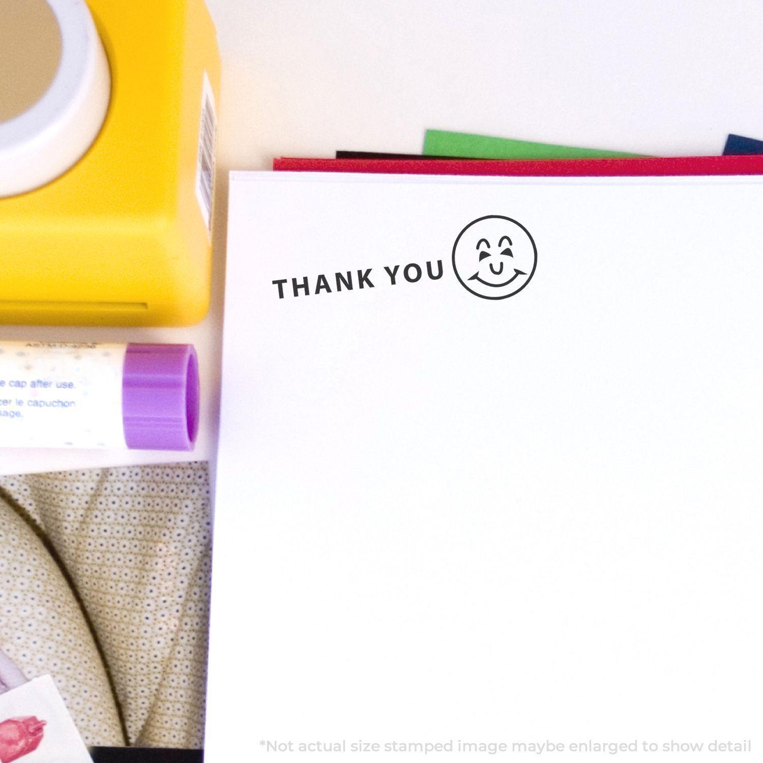 Large Self Inking Thank You with Smiley Stamp used on white paper, surrounded by colorful stationery items.