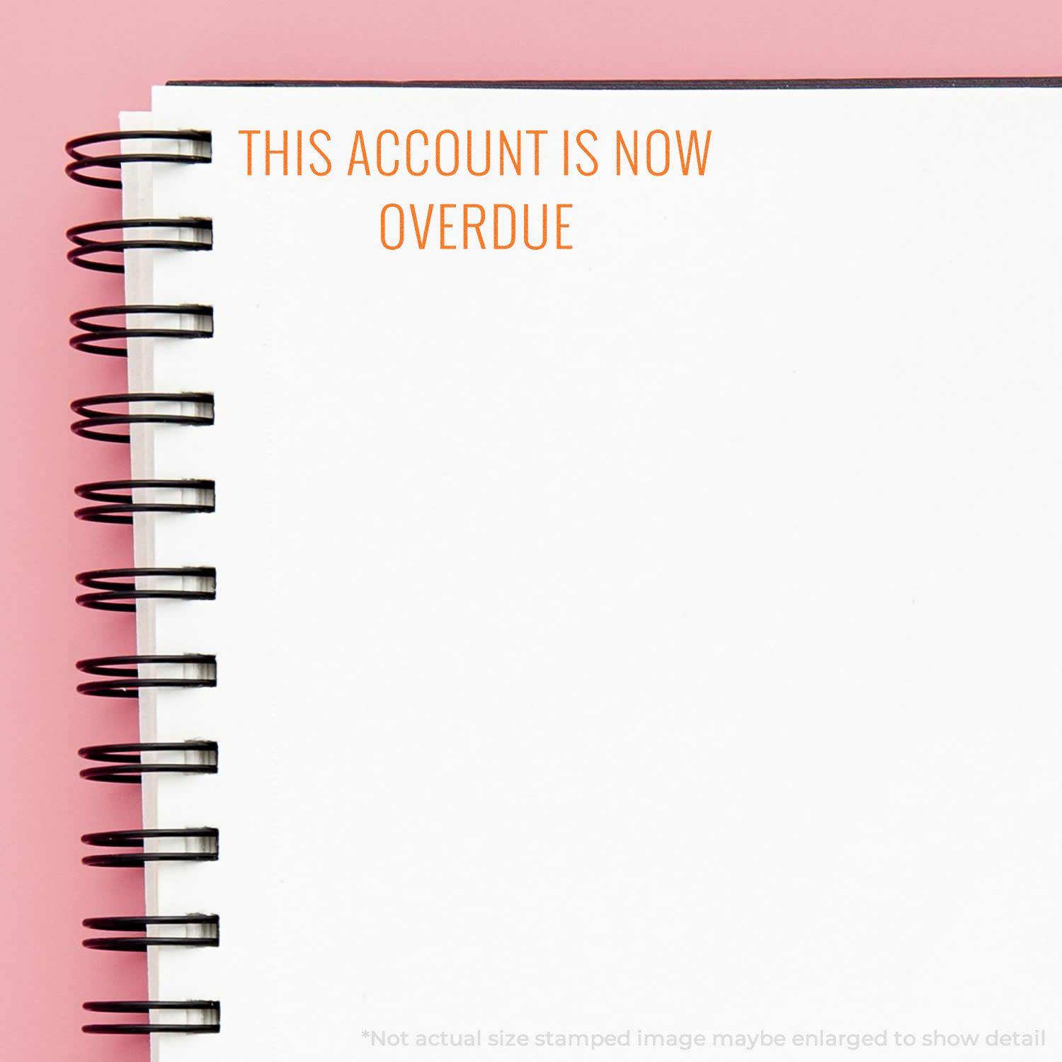 A notebook with a spiral binding has the text THIS ACCOUNT IS NOW OVERDUE stamped in red using the Self Inking This Account Is Now Overdue Stamp.