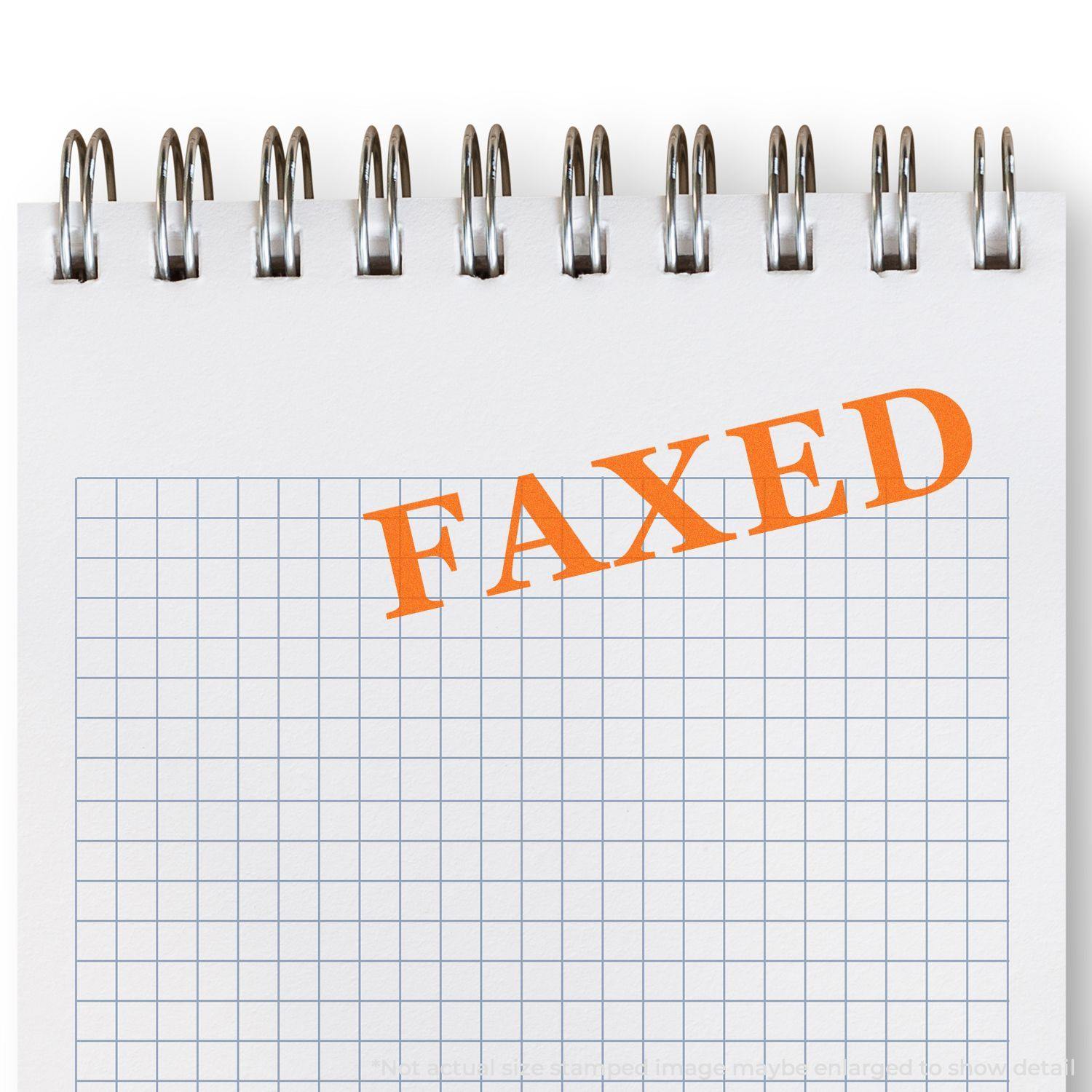 Large Pre-Inked Times Faxed Stamp marking FAXED in bold orange on a spiral-bound notepad with a grid pattern.