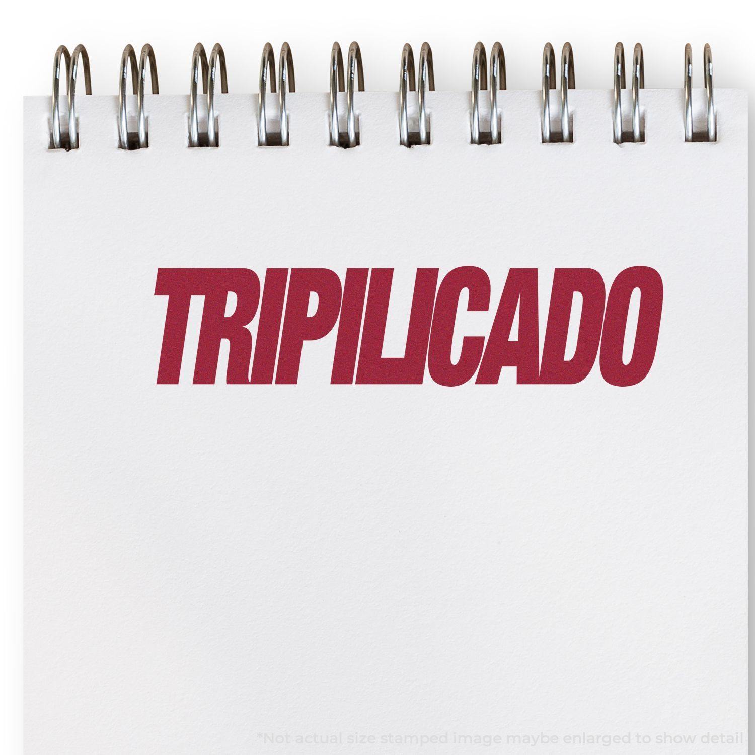 A notebook with a spiral binding displays a red "TRIPILICADO" stamp impression from the Tripilicado Rubber Stamp.