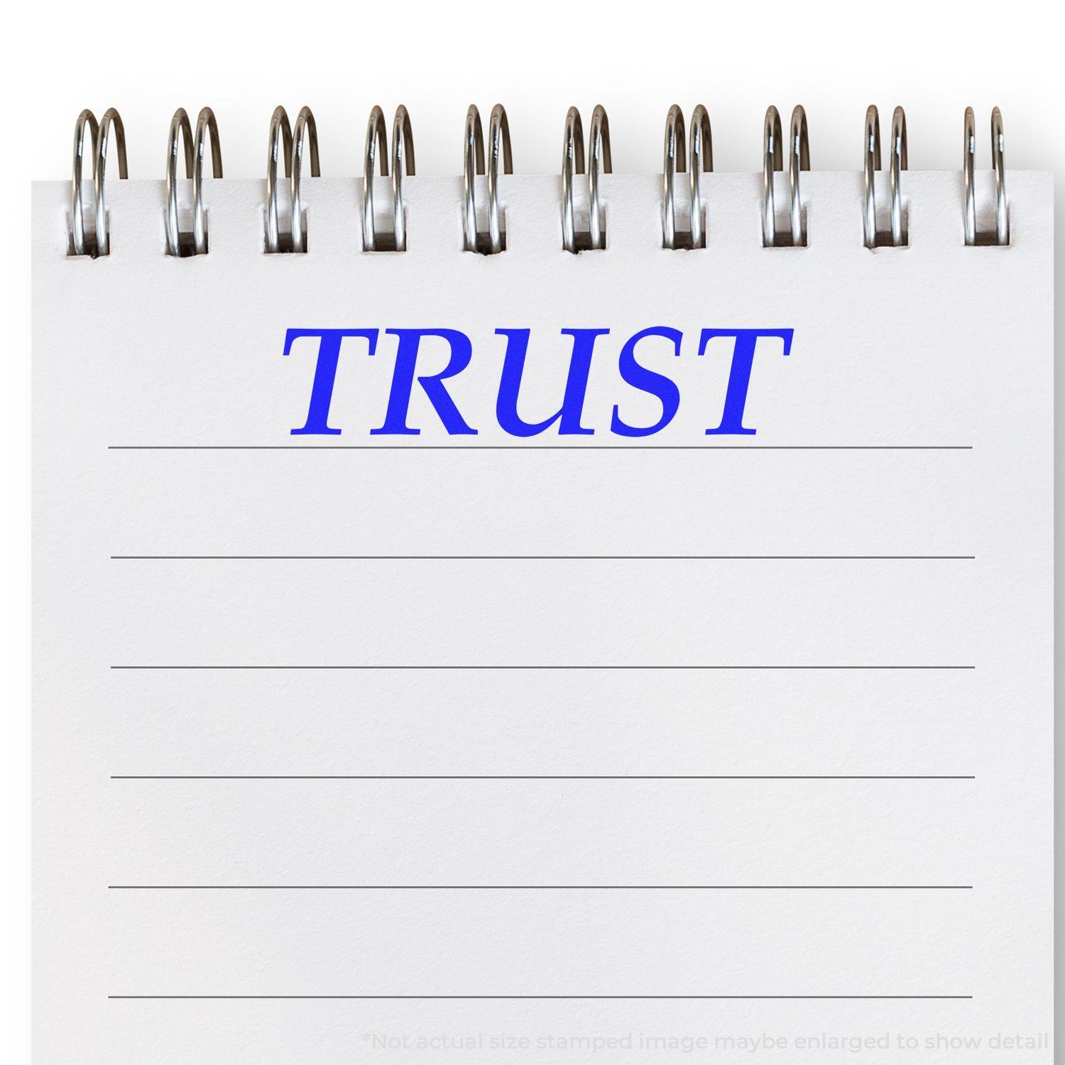 A Large Pre-Inked Trust Stamp imprint on a white notepad with blue TRUST text and lined paper.