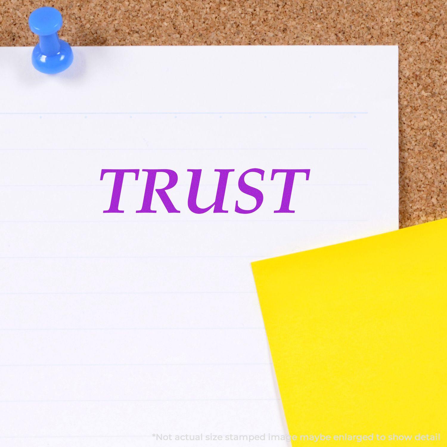 Trust rubber stamp on white paper pinned to a corkboard, with a yellow sticky note beside it.