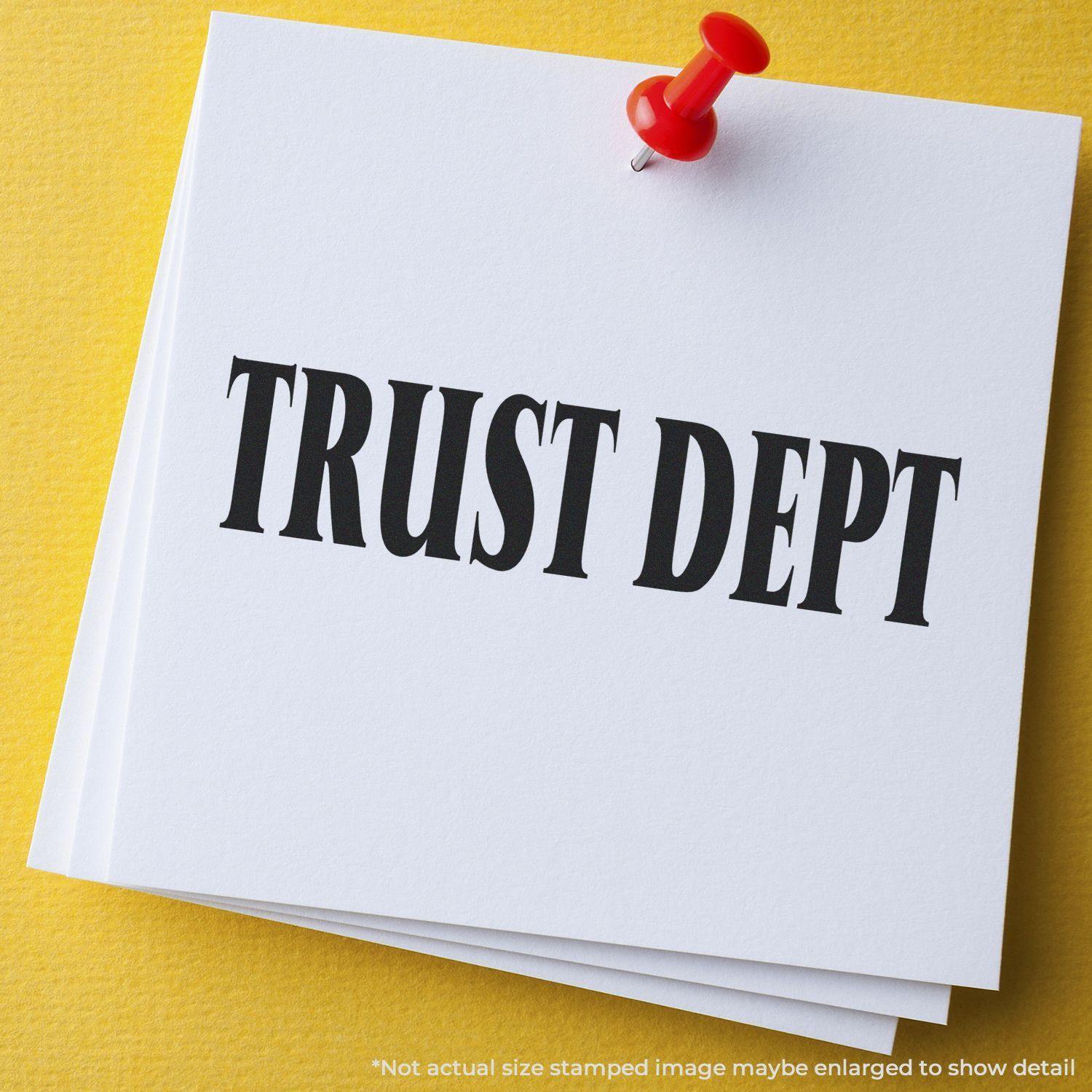 Self Inking Trust Dept Stamp imprint on white paper pinned to a yellow board, showcasing bold black text TRUST DEPT .