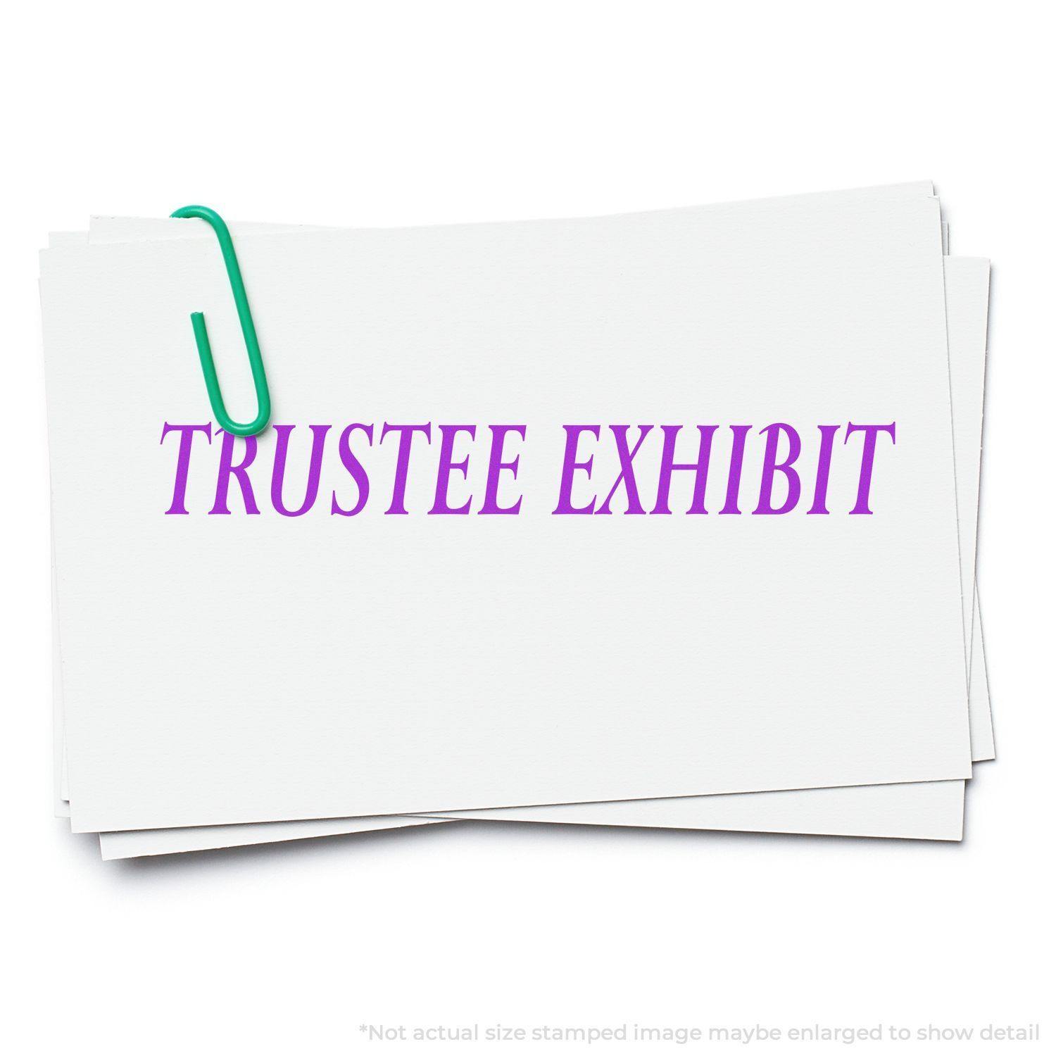 Large Pre-Inked Trustee Exhibit Stamp used on a stack of white cards with a green paperclip, displaying the text TRUSTEE EXHIBIT in purple.