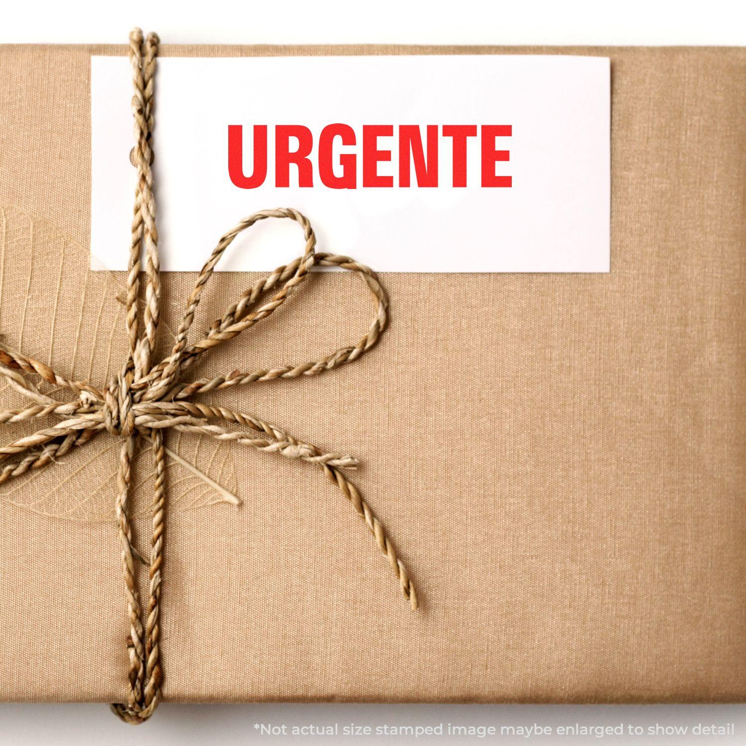 A package wrapped in brown paper with a card stamped URGENTE using the Large Pre-Inked Urgente Stamp, tied with a twine bow.