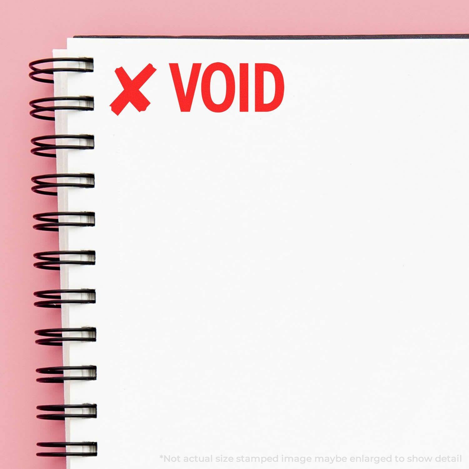 Large Self Inking Void with X Stamp marking a spiral notebook page with a red X and VOID text on a pink background.