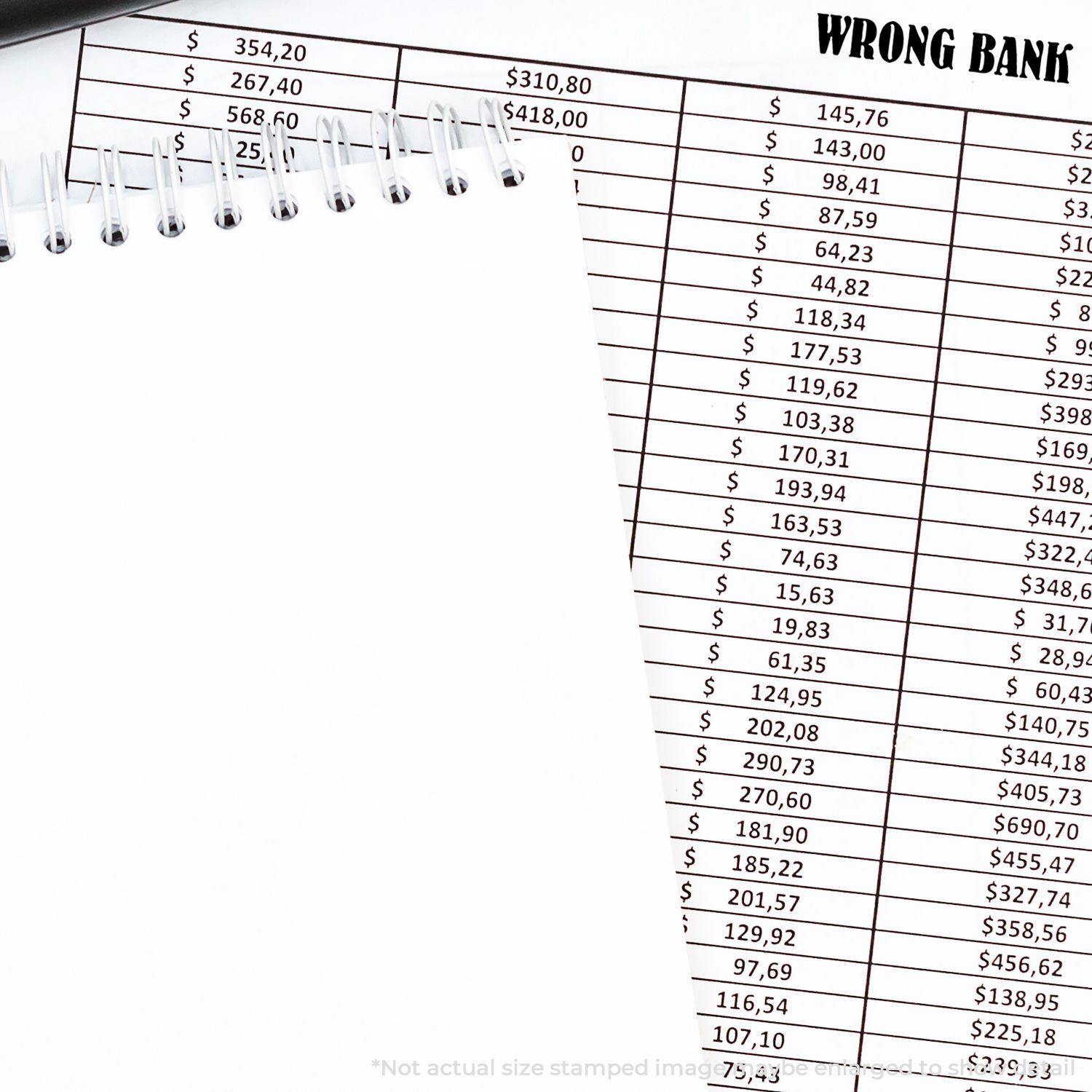 Slim Pre-Inked Wrong Bank Stamp used on a financial document with a spiral notebook and pen in the background.