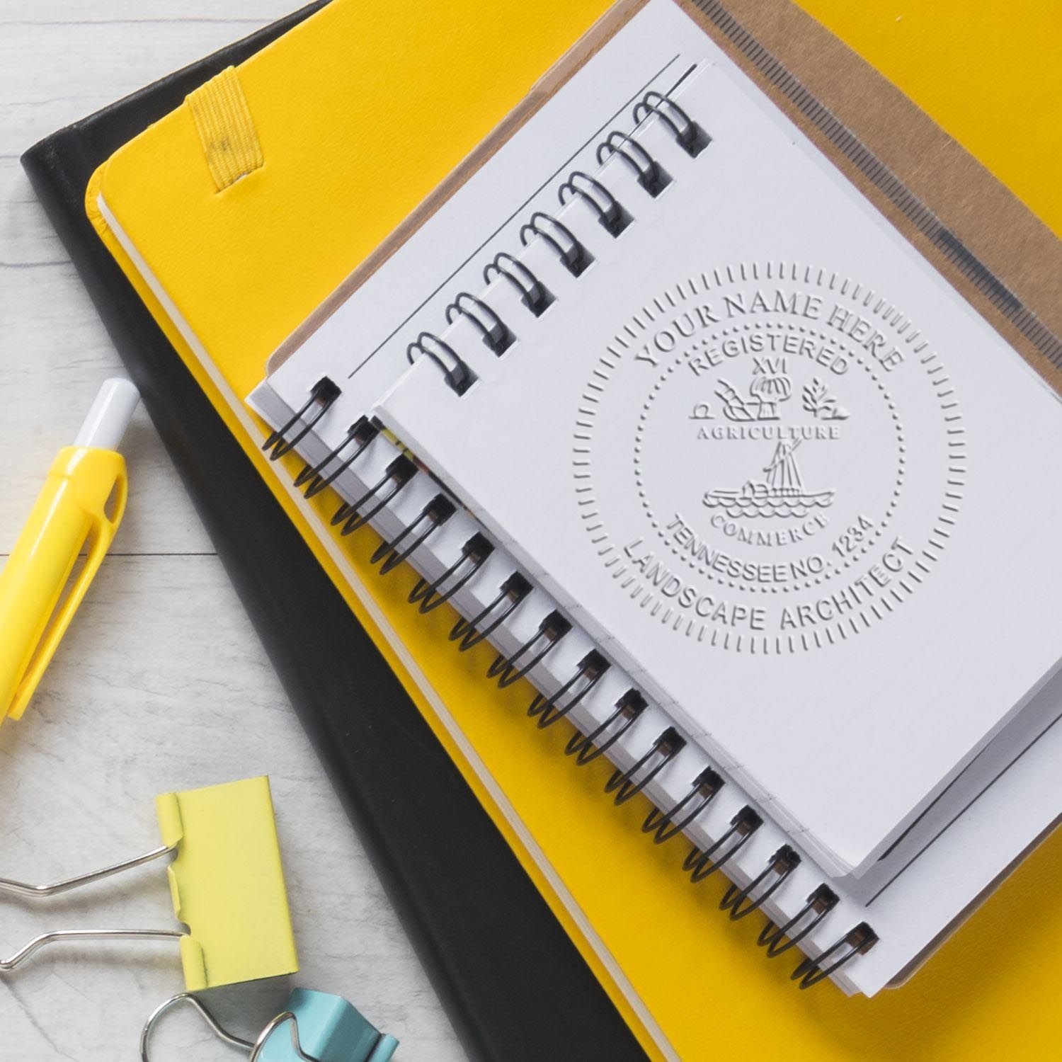 An in use photo of the Gift Tennessee Landscape Architect Seal showing a sample imprint on a cardstock