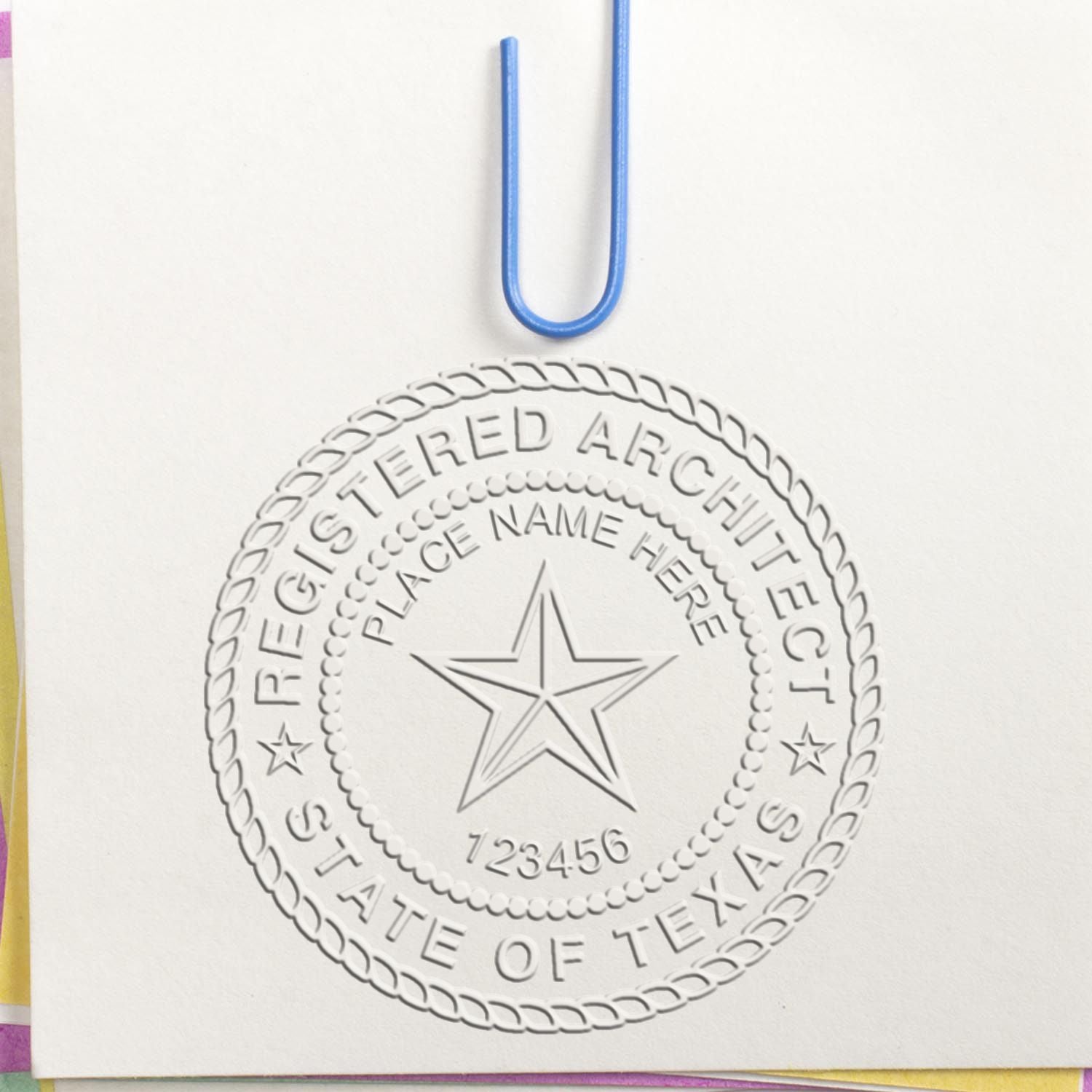 A lifestyle photo showing a stamped image of the Handheld Texas Architect Seal Embosser on a piece of paper