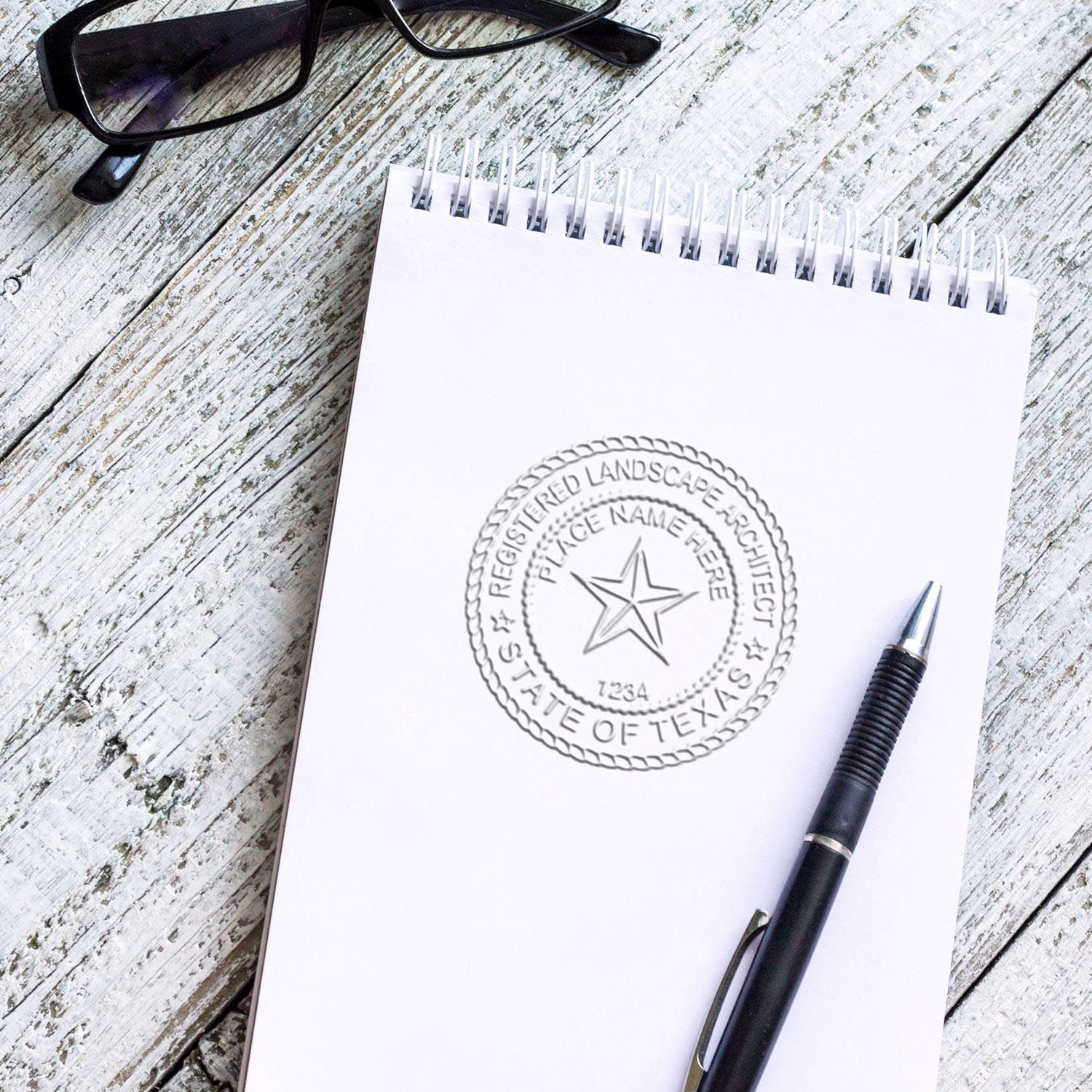 A lifestyle photo showing a stamped image of the State of Texas Extended Long Reach Landscape Architect Seal Embosser on a piece of paper