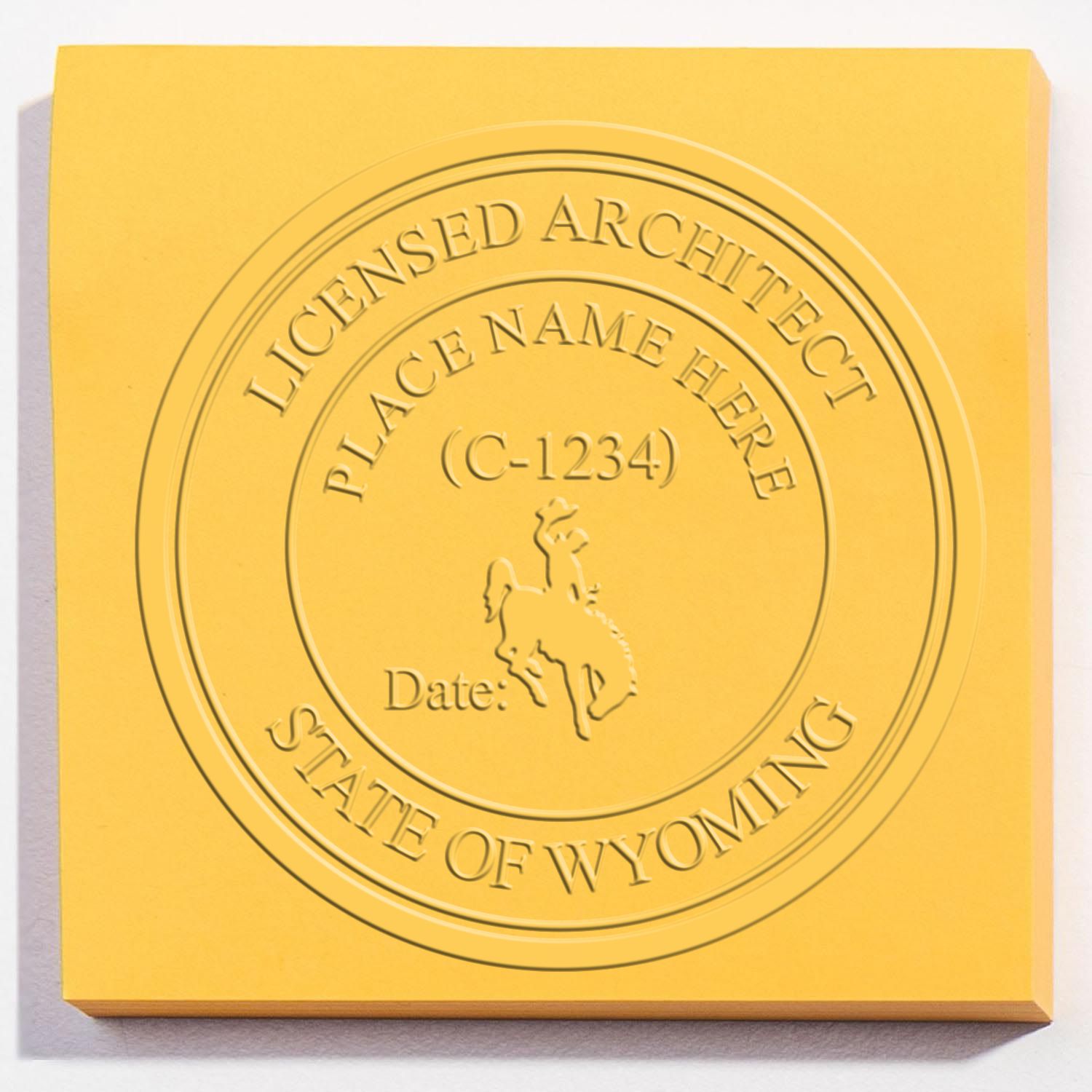 A lifestyle photo showing a stamped image of the Wyoming Desk Architect Embossing Seal on a piece of paper