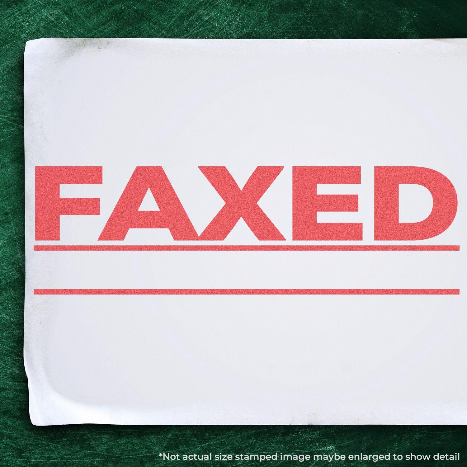 A white paper stamped with FAXED in bold red letters using the Jumbo Bold Red Faxed Xstamper Stamp, placed on a green surface.