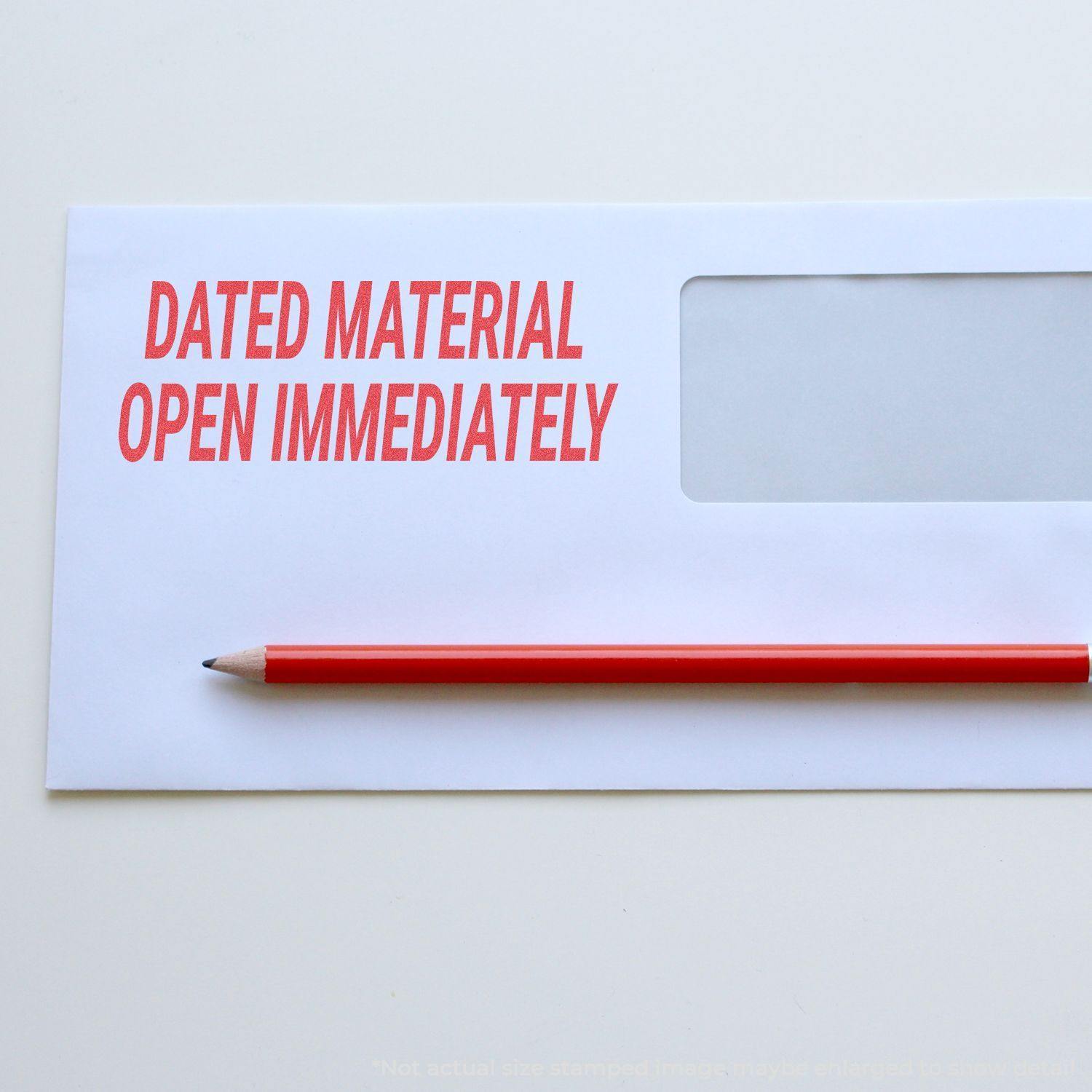 Envelope stamped with DATED MATERIAL OPEN IMMEDIATELY using the Jumbo Dated Material Open Immediately Xstamper Stamp, with a red pencil beside it.