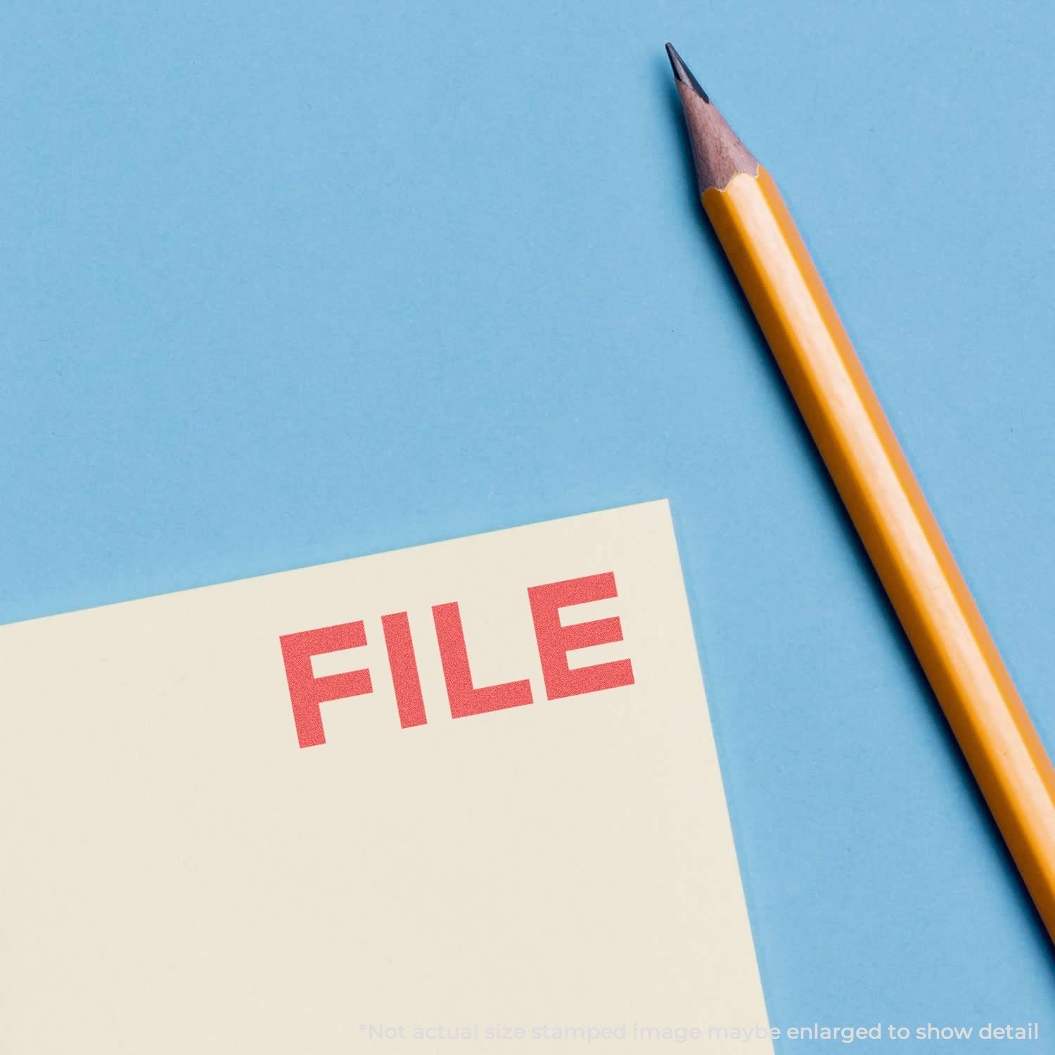 A yellow pencil next to a paper stamped with FILE in red using the Custom Self Inking Stamp Trodat 4910 Size 3/8 x 1-3/32.