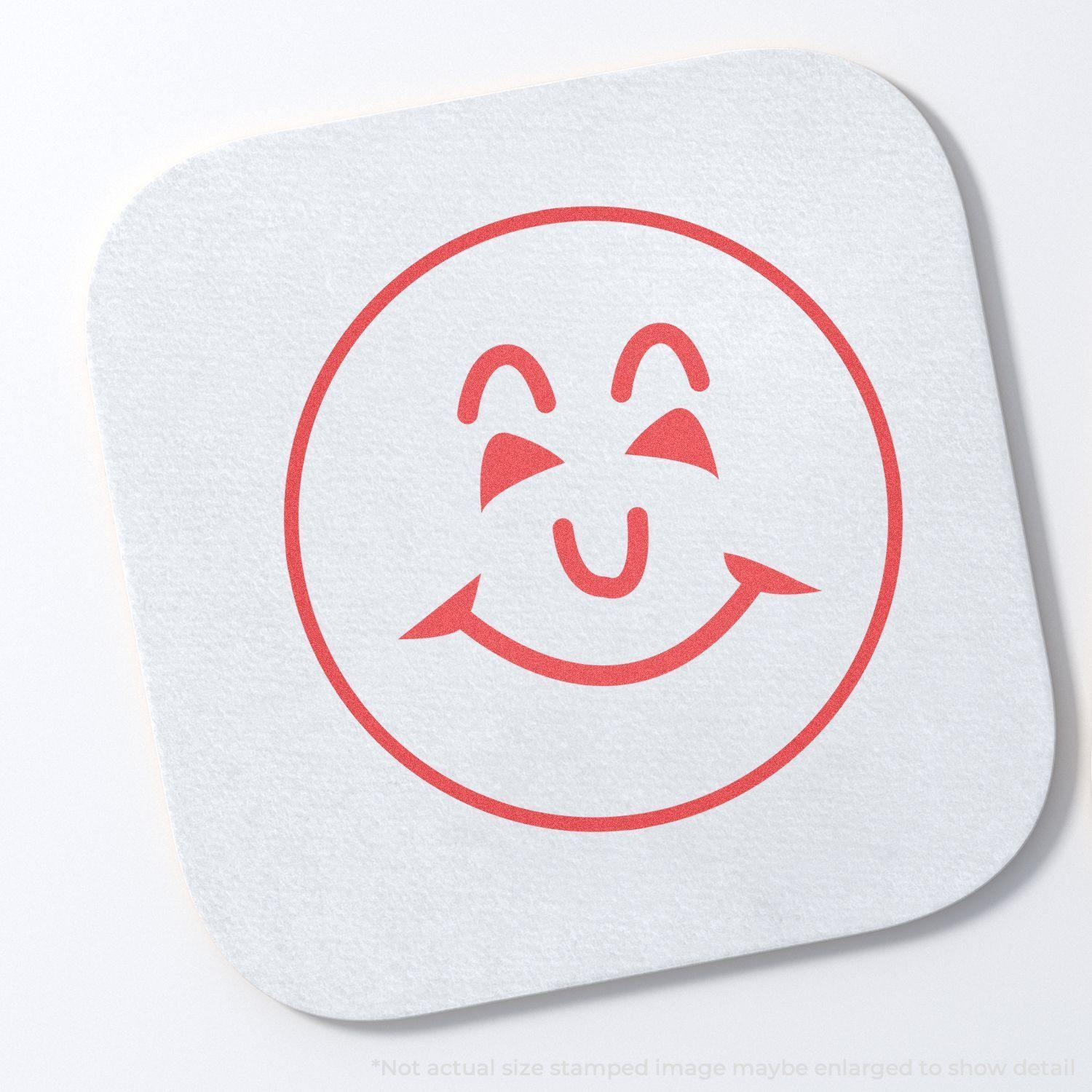 Round Smiley Face Xstamper Stamp imprint in red ink on a white square paper, showing a cheerful smiley face with closed eyes.