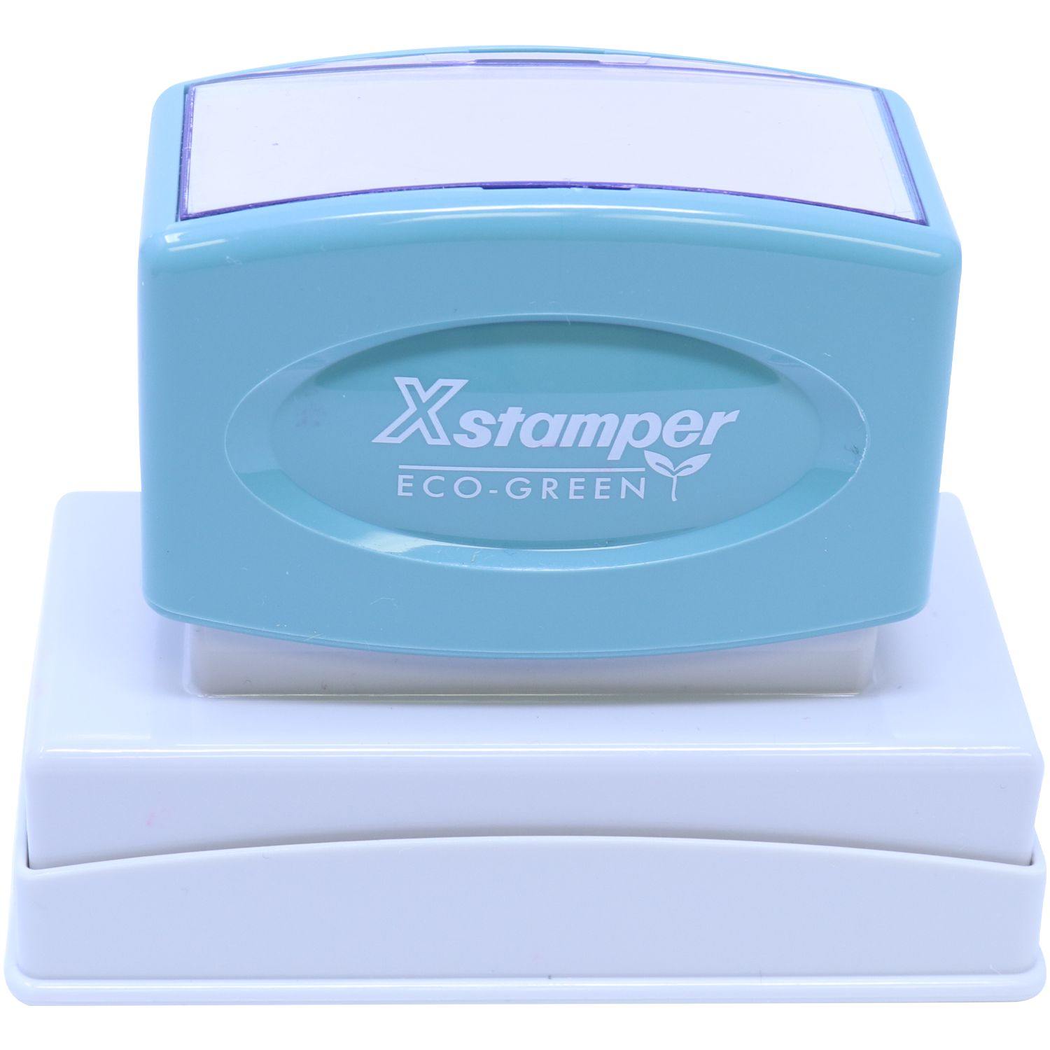 Jumbo Dated Material Open Immediately Xstamper Stamp in teal and white, with Xstamper ECO-GREEN logo, placed on a white base.